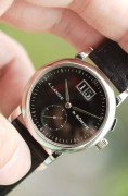 Saxonia 是 1994 年朗格复兴时推出的四款元祖表款之一，在品牌复兴方面发挥了核心作用。从借鉴自 Lange 1 的大日期到与 Tourbillon Pour le Mérite 相同的小钻石时标，早期 Saxonia 的设计抓住了时代精神。圆形表壳、内敛的尺寸和对称的表盘布局共同打造出一款适合当时品味的精致正装腕表。